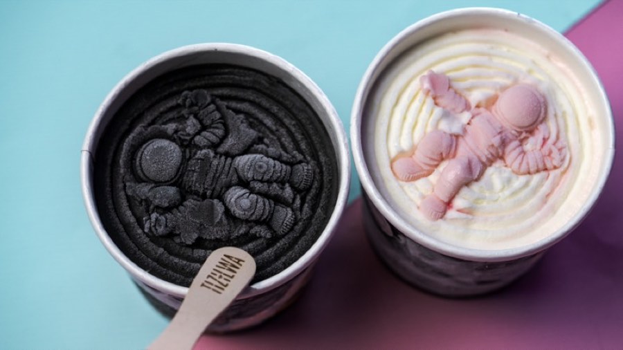 Two TIPO gelato tubs with astronaut molds and a TIZILWA spoon on a pastel pink and blue backdrop