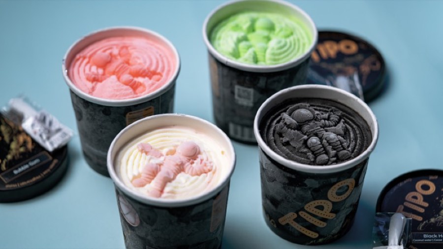 Several TIPO gelato tubs in pink, green, white and black with astronaut molds, seen from above