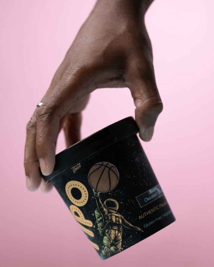 Hand holding a TIPO Bounty gelato tub with Authentic Italian branding against a pink backdrop