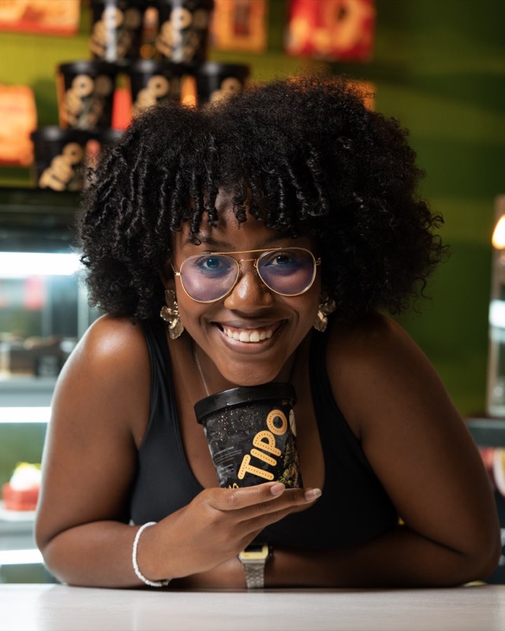 Happy customer smiling and holding a TIPO gelato tub in the Dhany's Delice store